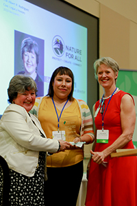 Nature for All's Belinda Faustinos poses with her Civic Legacy plaque and her finance liaison, Angelina Gonzalez and her program liaison, Judy Harper